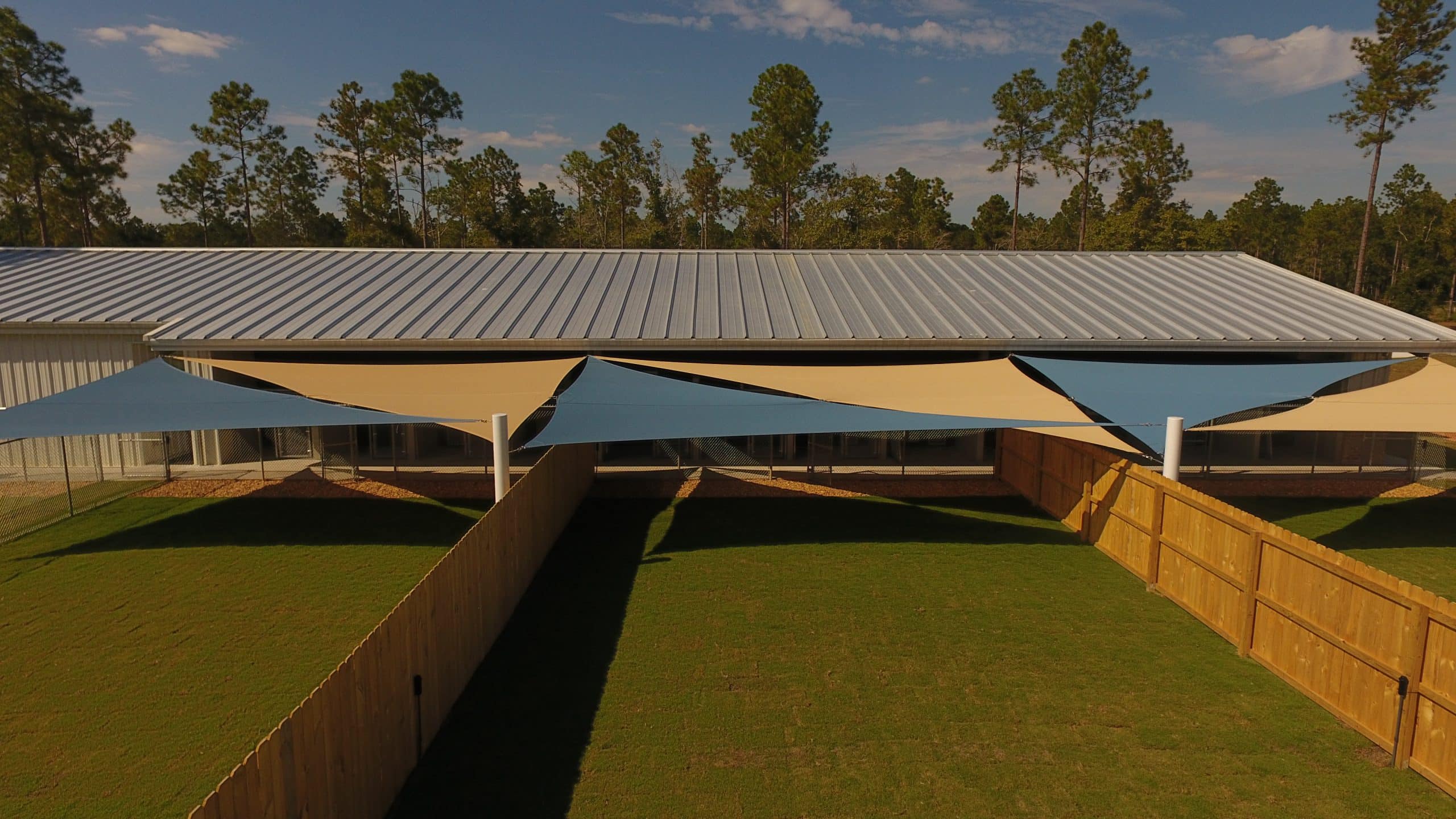 blue and tan shade sails installed at a compound by Emerald Coast Shade in Pensacola Florida