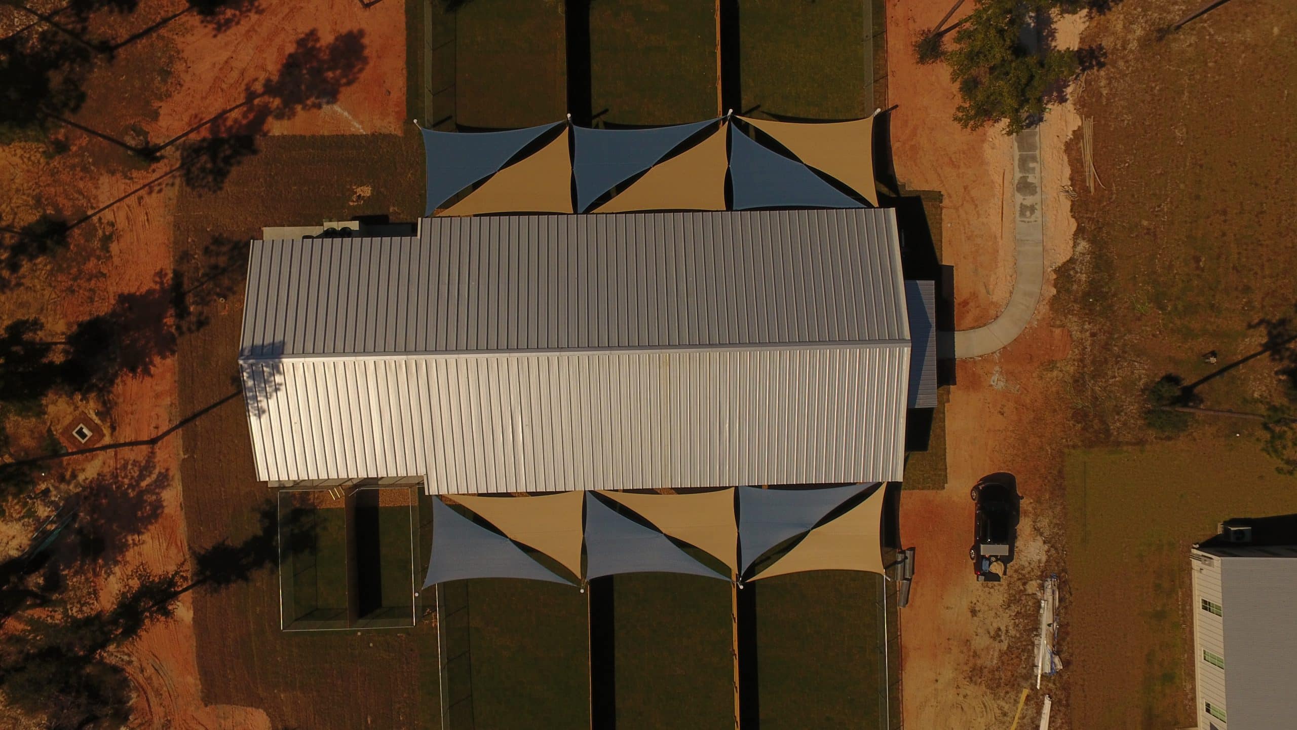 ariel view of blue and tan shade sails installed at a compound by Emerald Coast Shade in Pensacola Florida
