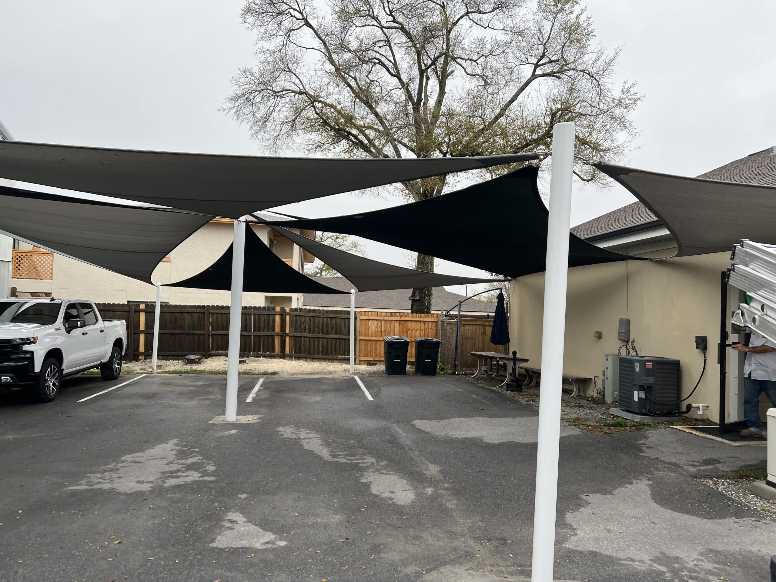 black shade sails installed over a parking lot by Emerald Coast Shade in Lynn Haven Florida